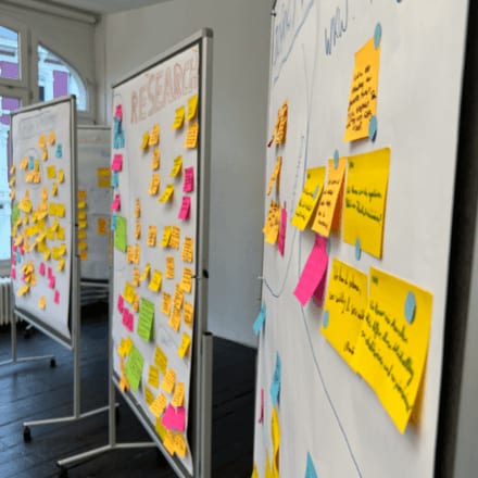 Foto von Whiteboards, auf dem beschriftete Workshop-Postits geklebt sind